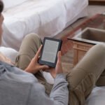 Young man reading an e-book on digital tablet device